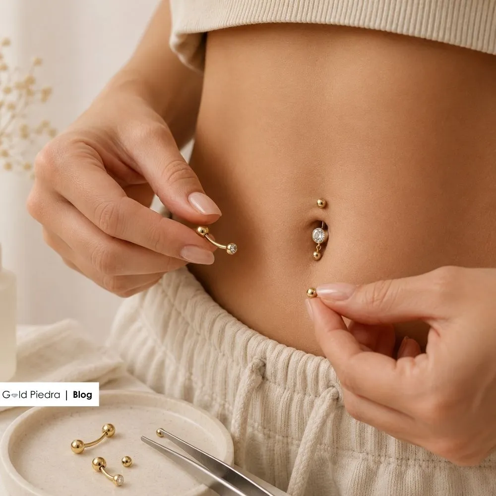 Göbek üstü kıvrım anatomisine uygun kavisli (banana bar) altın göbek piercing modelinin doğal açıyla yerleştirilmesi.